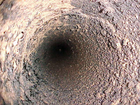 Soot-covered masonry flue before cleaning